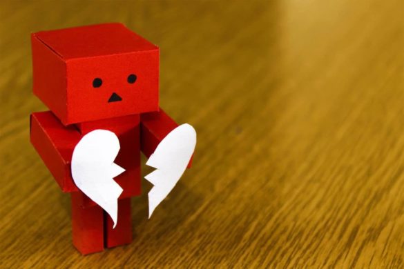 Sad robot holding a broken heart